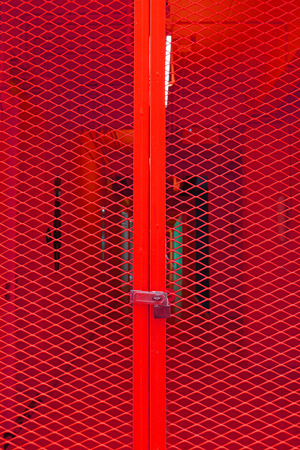 Red grating steel door with keyの写真素材