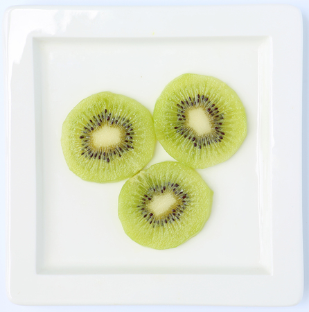 Cross section of ripe kiwi on white plateの写真素材