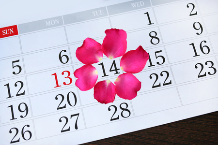 Calendar page with pink petals roses on February 14 of Saint Valentine's day.の写真素材