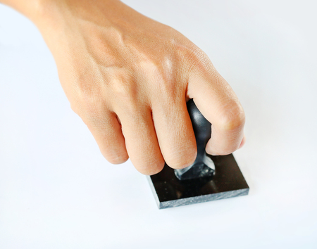 hand holding rubber stamp on white backgroundの写真素材