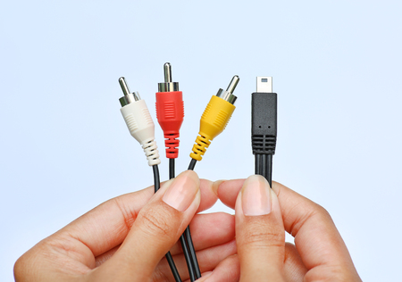 Hands holding USB video audio capture adapter VHS to DVD hdd tv card on a white backgroundの写真素材
