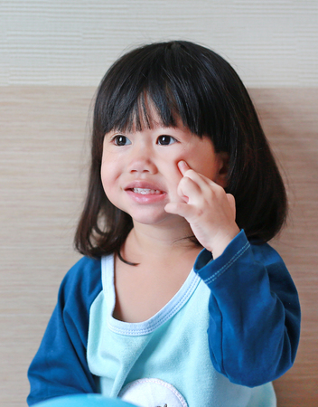 Close up cute little asian girl lying on bed.の写真素材