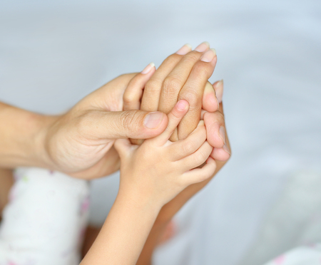 Loving hands clasped of Family father, mother and daughter.の写真素材