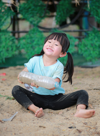 Cute little girl playing in garden with soilの写真素材