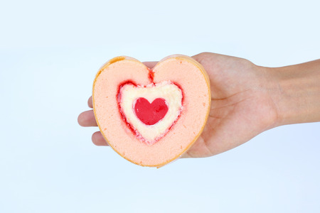 Woman hand holding Heart jam roll cakes on white backgroundの写真素材
