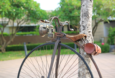 Retro bicycle with large front wheel in public park.の写真素材