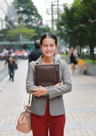 Beautiful young business woman walking outside. Asian businesswoman office worker in downtown business district.の写真素材