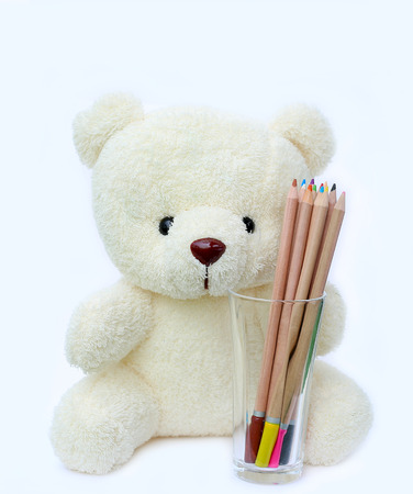Bear doll with colored pencils on white backgroundの写真素材