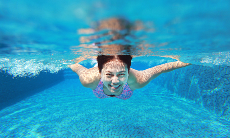 Young asian woman having fun underwater in swimming pool.の写真素材