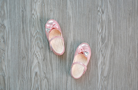 Girl's small shoes on woodの写真素材