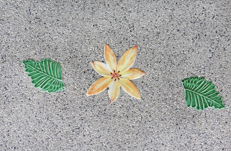 The textures of ceramic flower and leaf on groundの写真素材