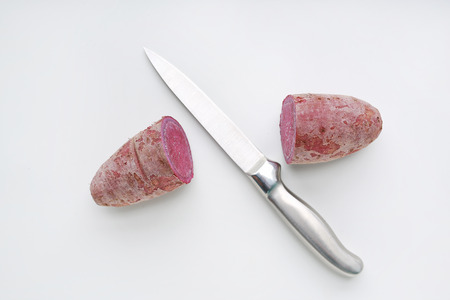 Sharp knife cut half purple sweet potatoes on white backgroundの写真素材