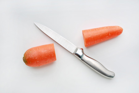 Sharp knife cut half carrot on white backgroundの写真素材