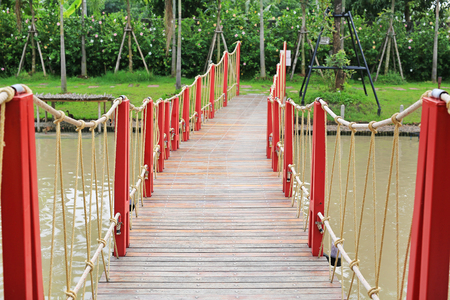 Wooden rope suspension bridge for walk crossing riverの写真素材