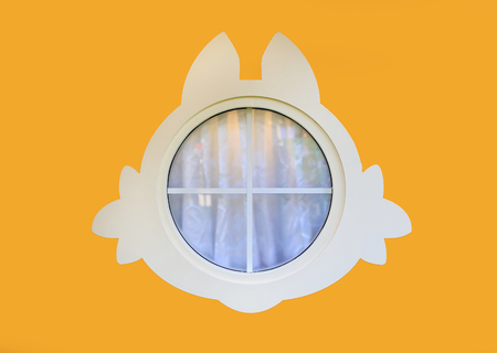 Cute glass window on yellow wall.