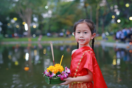 Loy Krathong festival, Asian Child girl in Thai traditional dress with holding krathong for forgiveness Goddess Ganges to celebrate festival in Thailand.の写真素材