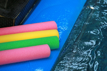 Water aerobic equipment. colored aqua noodles in swimming pool