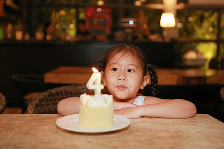 Adorable little Asian child girl with happy birthday cake 4 years old.の写真素材