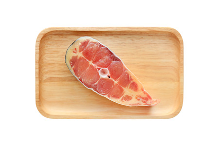 Sliced fresh Iridescent shark or Striped catfish on wooden plate isolated on white background.