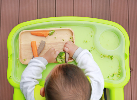 Top view of infant baby eating by Baby Led Weaning (BLW). Finger foods concept.の写真素材