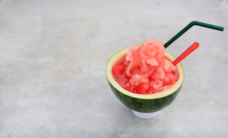 Fresh watermelon smoothie served in cut half watermelon shell place on stone table with copy space.の写真素材