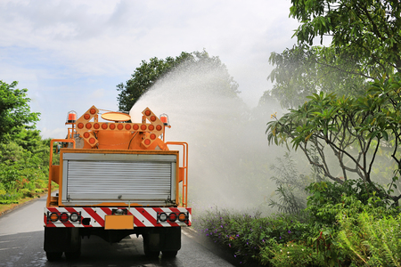 Truck watering a tree by spray water in the park garden.の写真素材