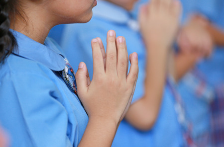 Close-up hands of kindergarten student pay respect teacher.の写真素材
