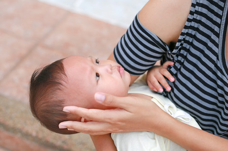 Close-up mother touching face of her baby boy.の写真素材