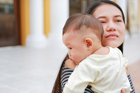 Asian mother carrying her infant. Close-up.の写真素材