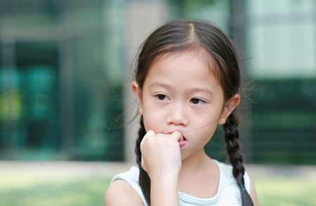 Child girl intend sucking her fingers. The gestures of children who lack confidence.の写真素材