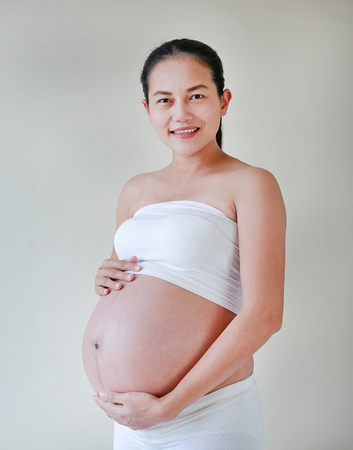 Happy pregnant woman holds her big belly.の写真素材