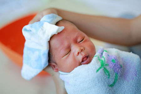 Mother bathing for her newborn baby.の写真素材