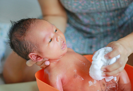 Close up foot of newborn baby bath in bathtub.の写真素材