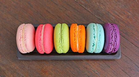Colorful macarons in a rows on the woodの写真素材