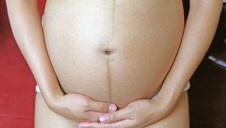 Pregnant Woman holding her hands on her tummy.の写真素材