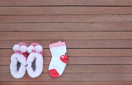 Cute baby shoes with socks on wood plank, Little shoe on wood floor with copy space, Top viewの写真素材