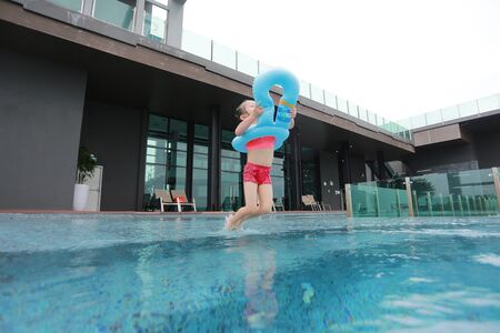 Asian Child girl has fun and jumping in the pool.
