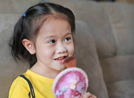 Close up Asian child girl doing makeup.
