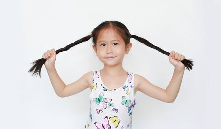 Happy of little Asian child girl holding pigtail on white background. Portrait smiling kid with two pigtails.の写真素材