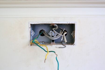 Bare wire at house wall. Unsafe and dangerous.の写真素材