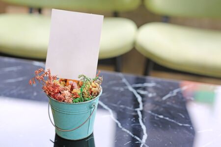 White blank paper label menu frame in mini flower pot on table at Bar restaurant.の写真素材