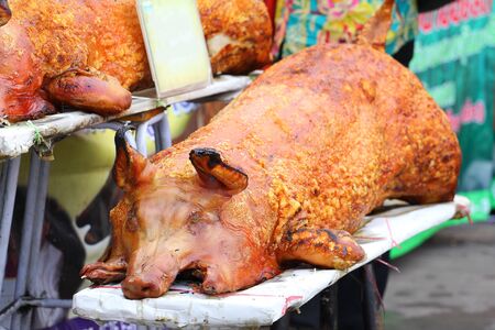 Golden whole roasted pig. Spit roasting is a traditional international luau method of cooking a...