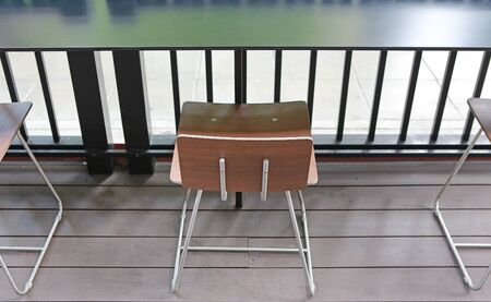 Long wood desk with chair at outdoor cafe.