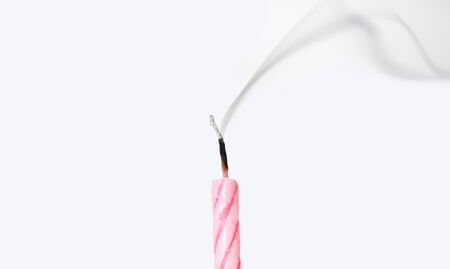 Candle with smoke blown out on white background.の写真素材
