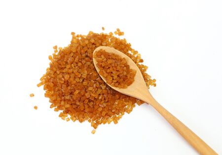 Brown sugar and wooden spoon on white backgroundの写真素材