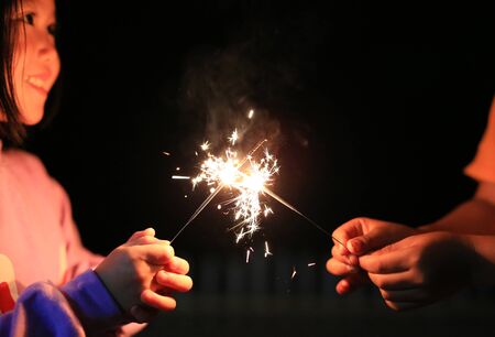 Children are playing with fire sparklers on the festival.の写真素材