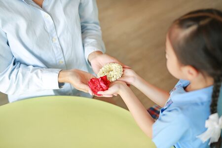Close up Asian daughter Pay respect and give Thai traditional jasmine garland to mother. Mother's day in thailand.の写真素材