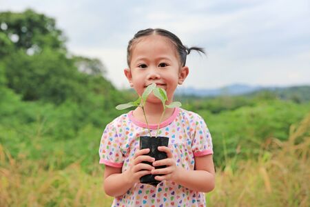 Child holding young seedling plant in hands. Concept Earth day.の写真素材