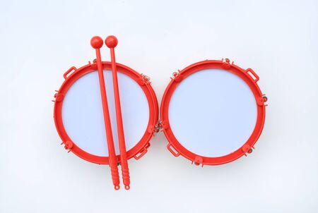 Drum with sticks children's musical instrument on white background.