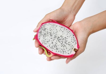 Female hand holds ripe dragon fruit on white backgroundの写真素材